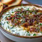 Warm smoked Gouda and onion dip scoops easily with a tortilla chip, paired with crisp veggies for a party.