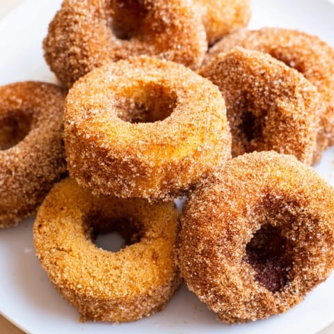 Freshly baked apple cider donuts, dusted with sweet cinnamon, ready to be enjoyed with coffee.