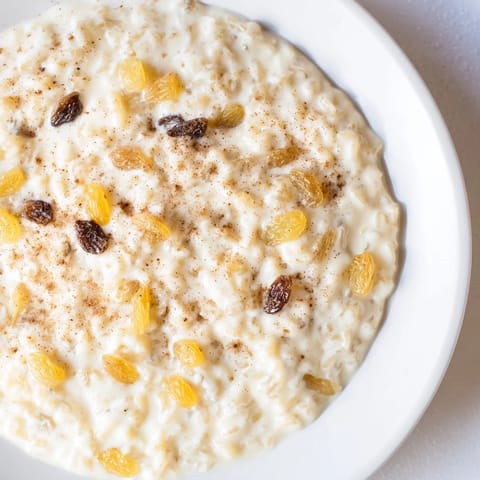 A warm bowl of rice pudding, studded with plump raisins and sprinkled with nutmeg.