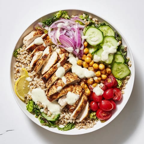 Bright cherry tomatoes and creamy chickpeas add color and crunch to this wholesome Lemon Tahini Chicken Power Bowl.