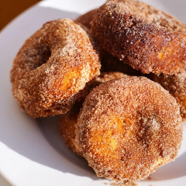 Warm, cake-like apple cider donuts, offering a delightful blend of apple cider and spice flavors.